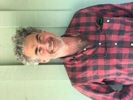 White man with curly gray hair smiling