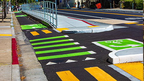 Street with protected bike lane, striped crosswalk