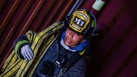 Firefighter carrying a hose