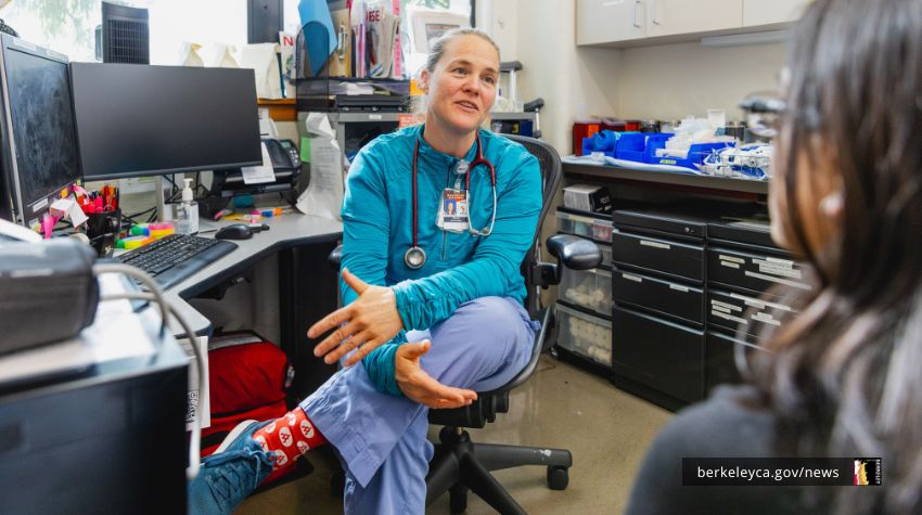 Woman wearing a stethoscope talking to a patient