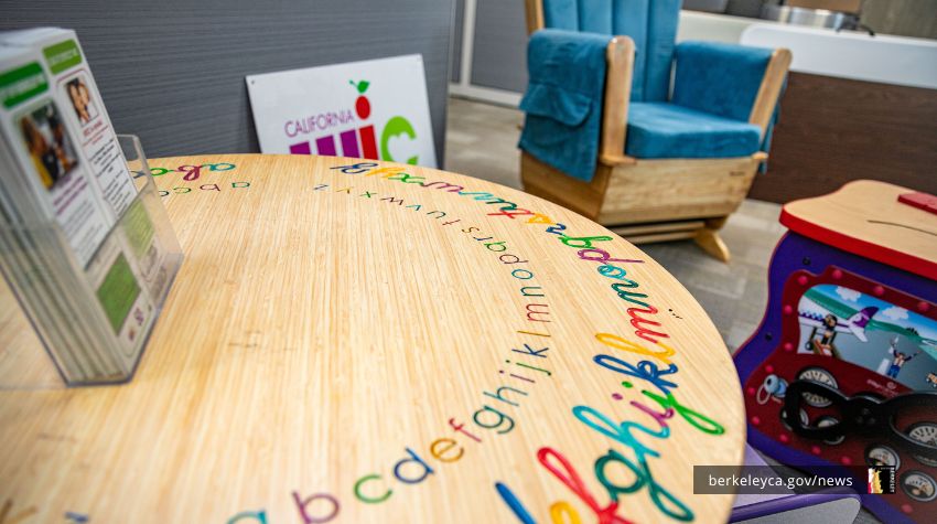 Colorful children's table with WIC sign and nursing chair in background